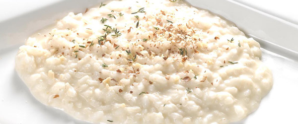 Risotto mantecato al Taleggio D.O.P. con granella di nocciole tostate, flambato al cognac